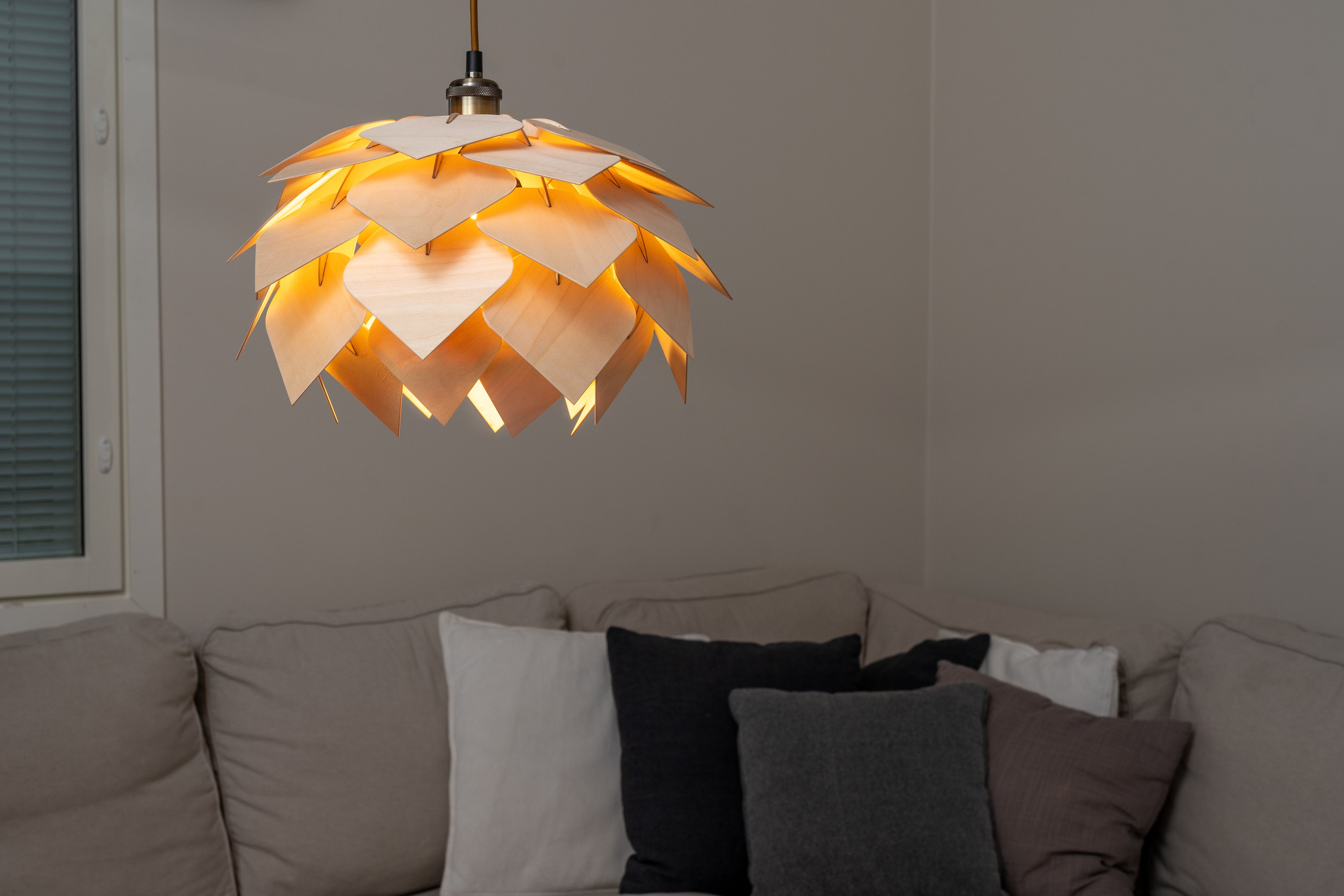 Koivuvanerista valmistettu Käpy varjostin olohuoneessa